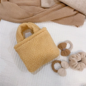 Mini sac à main en polaire jaune gingembre avec chouchous assortis sur fond de tissu doux