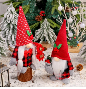 Detail of knit Christmas gnomes with red hats and checkered clothes in festive snow scene