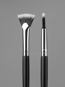 Macro shot of fan brush and flat eye shadow brush with black and white soft bristles