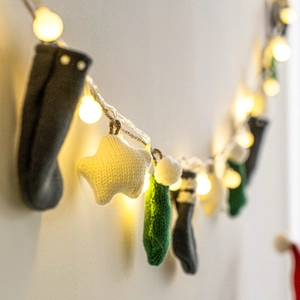 Luminous Christmas knit star and sock banner with warm LED lights for wall decor