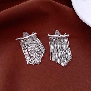 Détail de boucles d'oreilles longues à pompons argentés avec zircons brillants