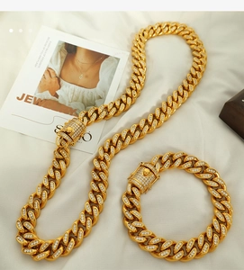 Detail of 18k gold plated Cuban link necklace and bracelet set with white cubic zirconia