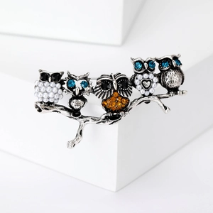 Detailed shot of alloy brooch featuring five owls on a branch with colorful rhinestones