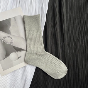 Detailed macro view of gray knitted mid-calf socks with ribbed texture on fabric