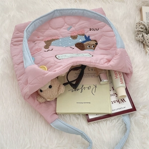 Detalle de un bolso tote rosa acolchado mostrando gran capacidad para libros y juguetes