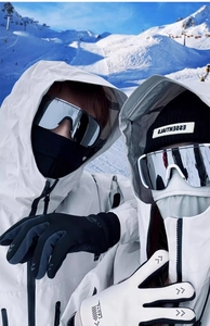 Close-up of white outdoor sports jacket with silver mirrored ski goggles and black gloves