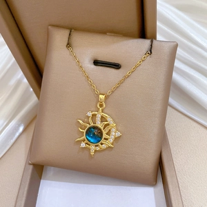 Detailed close-up of a gold star and moon necklace with blue gemstone and fine crystals