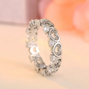 Close-up of silver-tone stacking ring with hollow hearts and sparkling zircon stones