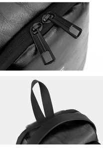 Detail view of smooth double zippers and sturdy nylon handle on the black leather chest bag