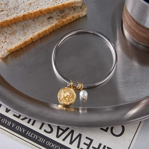 Vintage coin charm bracelet with silver band, gold angel coin and white pearl