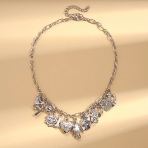 Detail view of silver multi-pendant necklace with sun heart and hand charms charms