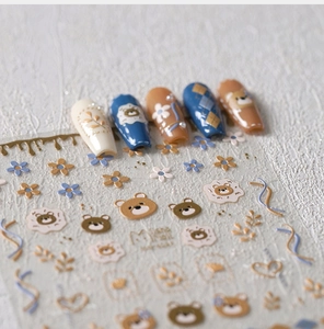 Macro view of 3D embossed bear nail art stickers with matte texture and floral patterns