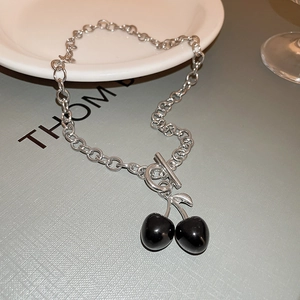 Detailed shot of silver chunky chain necklace with black cherry pendant and toggle clasp