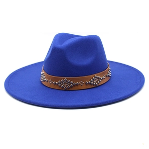 Dettaglio cappello di lana blu reale con cintura in pelle marrone e borchie argentate