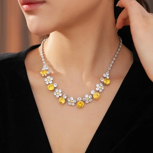 Detailed view of luxury flower necklace with yellow stones worn by a fashion model