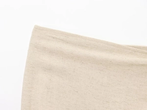 Dettaglio macro del tessuto in misto lino beige con cuciture rifinite e trama naturale