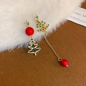 Dettaglio di orecchini asimmetrici ad albero di Natale con strass verdi e perline rosse