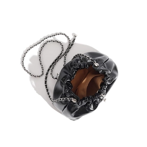 Top view of black ruched cloud bag showing brown interior lining and silver chain strap
