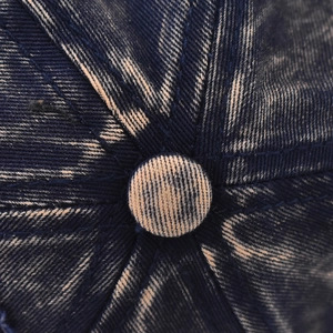 Close-up of the vintage washed denim baseball cap showing top button and stitching details
