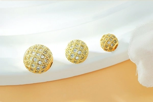 Macro detail of three gold plated beads with micro paved cubic zirconia and center holes