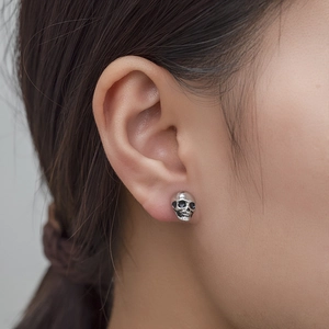 Punk vintage zinc alloy skull stud earring shown worn on a model ear lobe