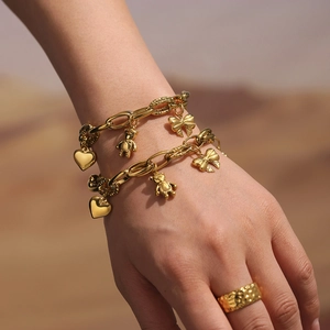 Gold-plated chain bracelet with bear and heart charms and hammered ring set on model