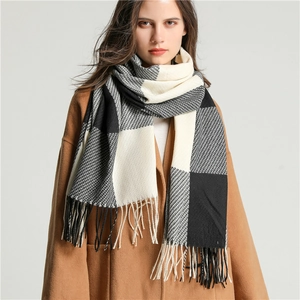 Detail of color-block plaid scarf showing soft knitted texture and tassel edges