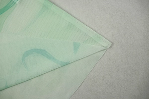 Close-up of lightweight light green mesh fabric texture with fine honeycomb mesh structure