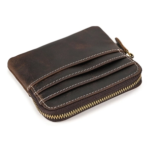 Detail of vintage brown leather coin purse showing stitching and side zipper texture