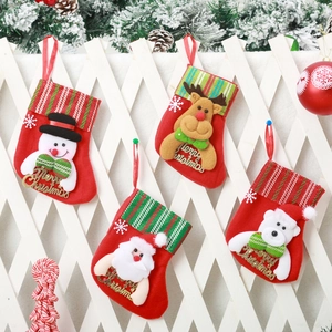 Detail of four festive felt Christmas stockings with 3D characters on white fence