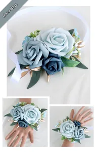 Close-up of mist blue silk roses and green leaves on a bridal wrist corsage