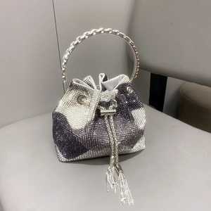 Dettaglio della borsa a secchiello in strass argento con manico rotondo in metallo su pelle