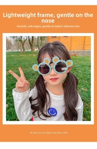 Close-up of a child wearing cute mint green bear ear sunglasses outdoors.