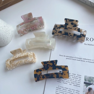 Detailed flat lay of five medium square acetate hair claws in assorted leopard and marble prints