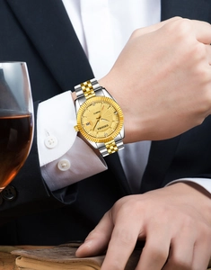 Detail of luxury DEDIMA men's gold watch with date display on leather-clad wrist