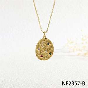 Macro shot of gold pendant featuring moon, star and eye motifs with colorful cubic zirconia