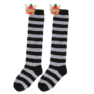 Close-up of black and grey striped Christmas stockings with cute reindeer doll details