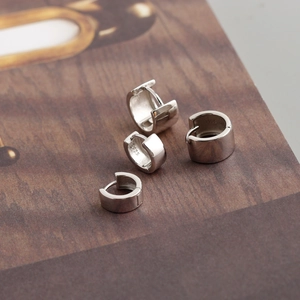 Macro shot of four high-polish 925 sterling silver hoop earrings with secure clasps