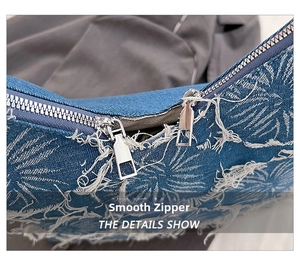 Detail of metal zipper on blue washed denim tote with white tropical palm leaf prints