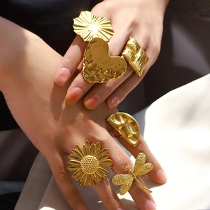 Exaggerated gold textured stainless steel rings featuring heart and flower designs