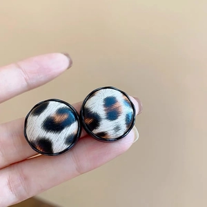Close-up of vintage leopard print hoop earrings with black border and smooth finish