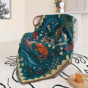 Close-up of bohemian woven dinosaur blanket with colorful fringe on a rattan chair