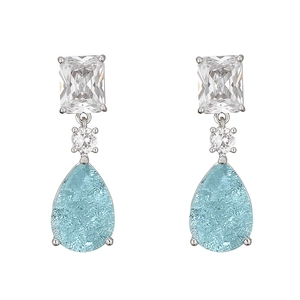 Macro view of silver water drop earrings featuring light blue crackle gemstones and zircons