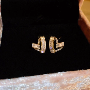 Macro view of gold-plated geometric heart earrings with sparkling cubic zirconia