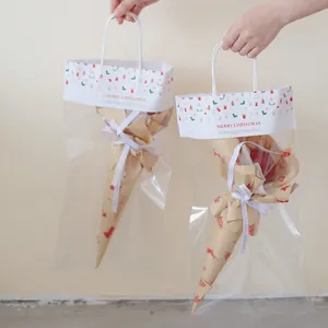 Transparent Christmas gift bag with festive patterns holding a wrapped floral bouquet
