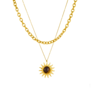 Double-layered gold necklace with sun pendant and tiger eye stone on white background