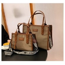 Detail view of khaki canvas tote bags in two sizes with luxury logo wide shoulder straps
