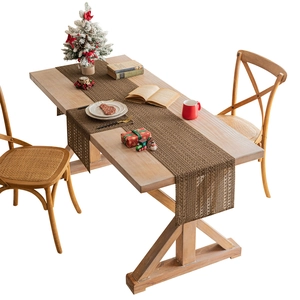 Brown woven Christmas table runner on wooden table with holiday decorations