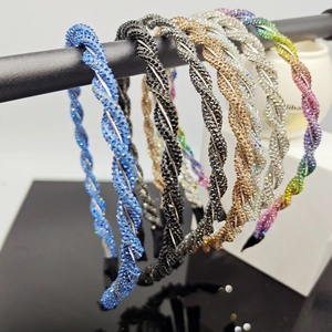 Detailed macro view of crystal headbands in blue, black, silver, and gold twisted designs