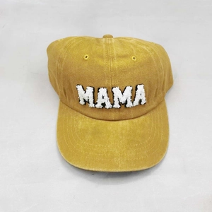 Detail of mama embroidery on yellow washed cotton baseball cap with vintage texture